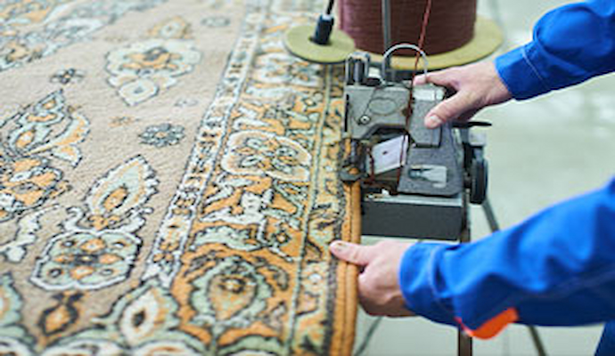 Professional repairing a rug using equipment